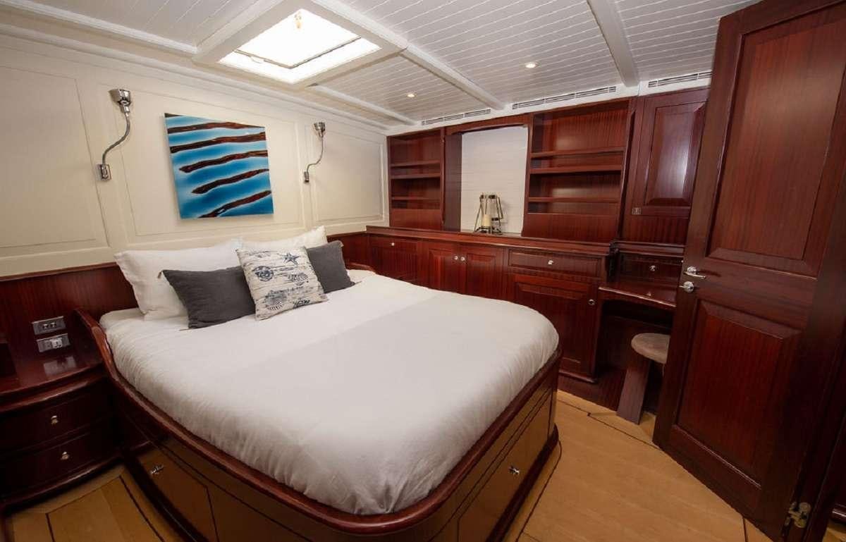 a bedroom with a bed and a desk aboard AURELIUS 111 Yacht for Charter