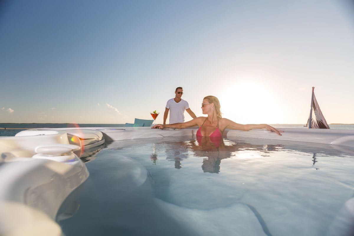 a man and woman in a pool aboard UNBRIDLED Yacht for Charter
