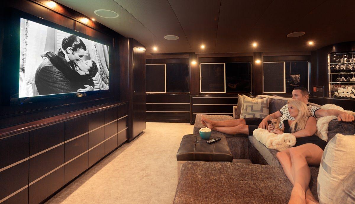 a man and a woman on a couch watching tv aboard UNBRIDLED Yacht for Charter