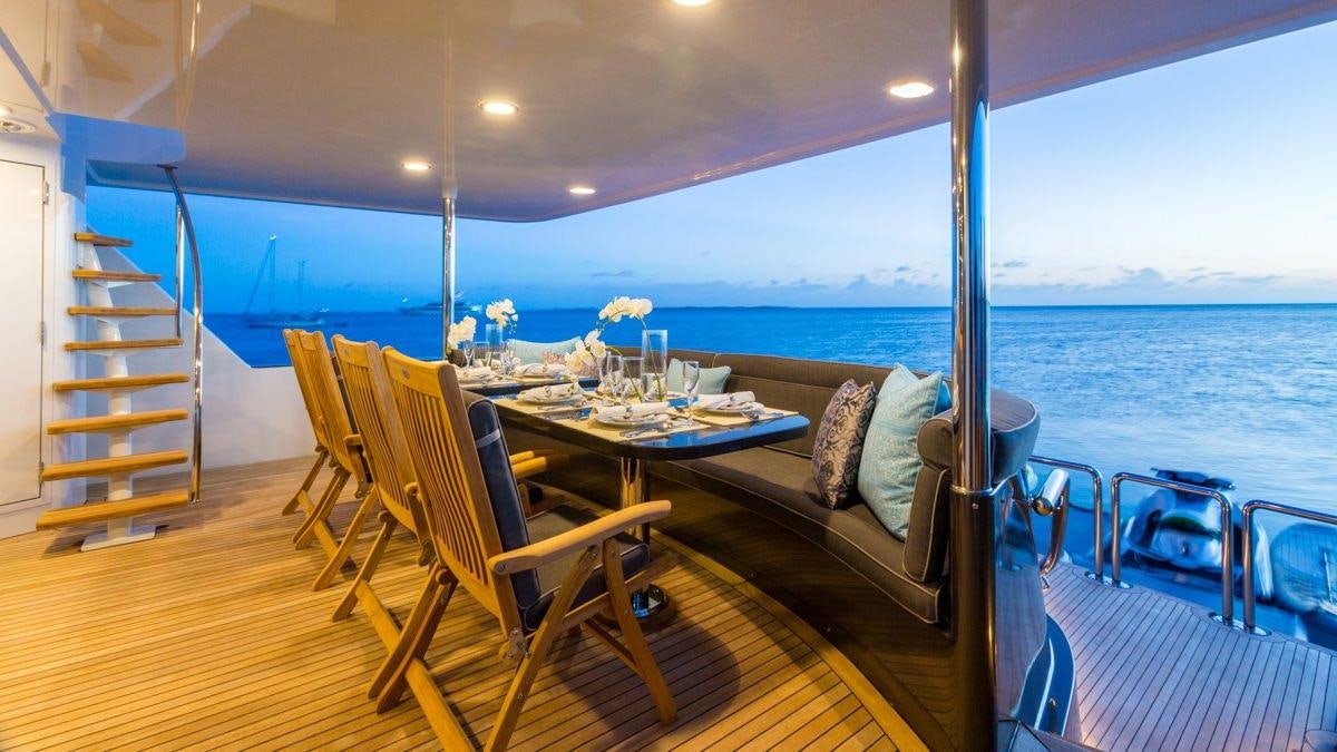 a balcony with a table and chairs aboard UNBRIDLED Yacht for Charter