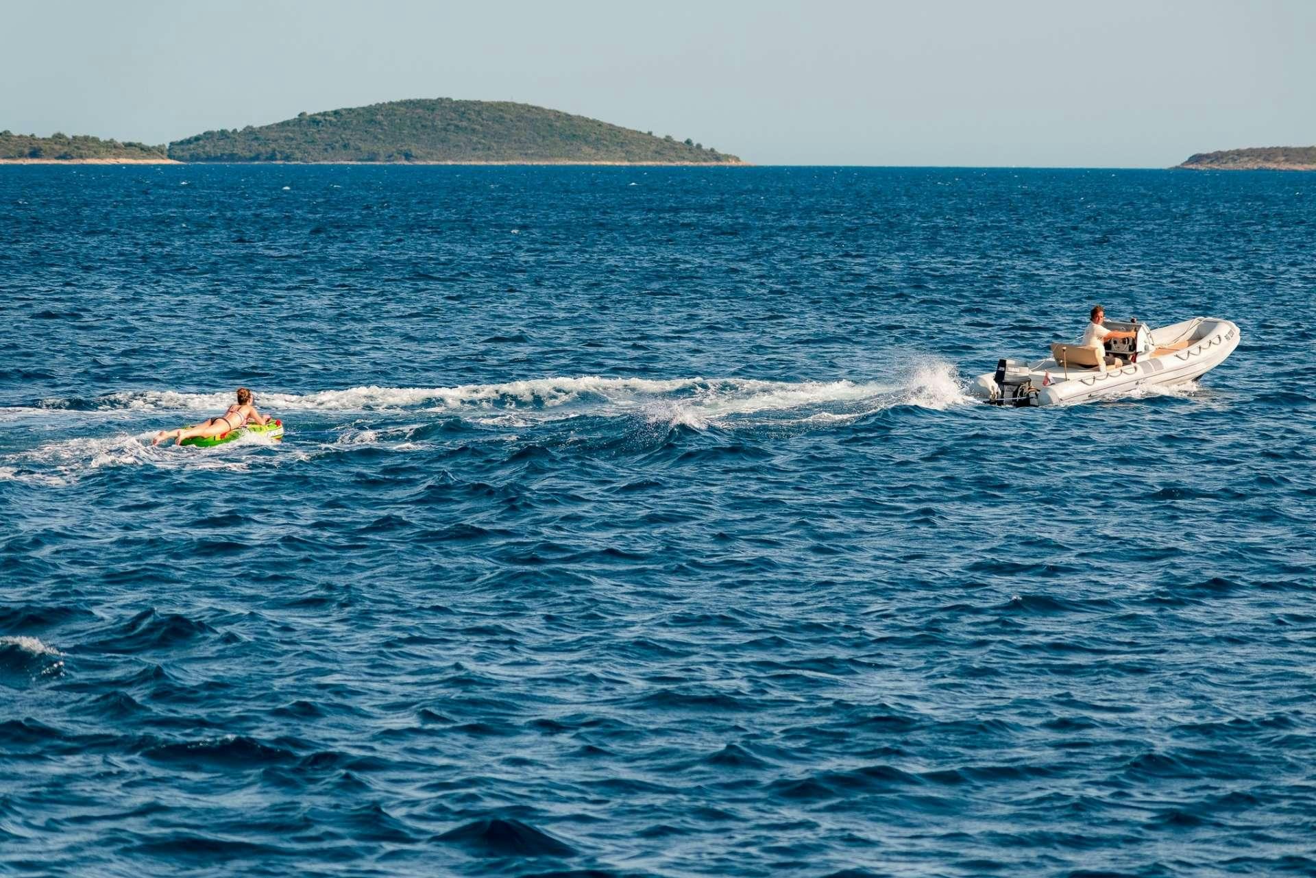 a couple of people on surfboards in the ocean aboard Dona Yacht for Charter