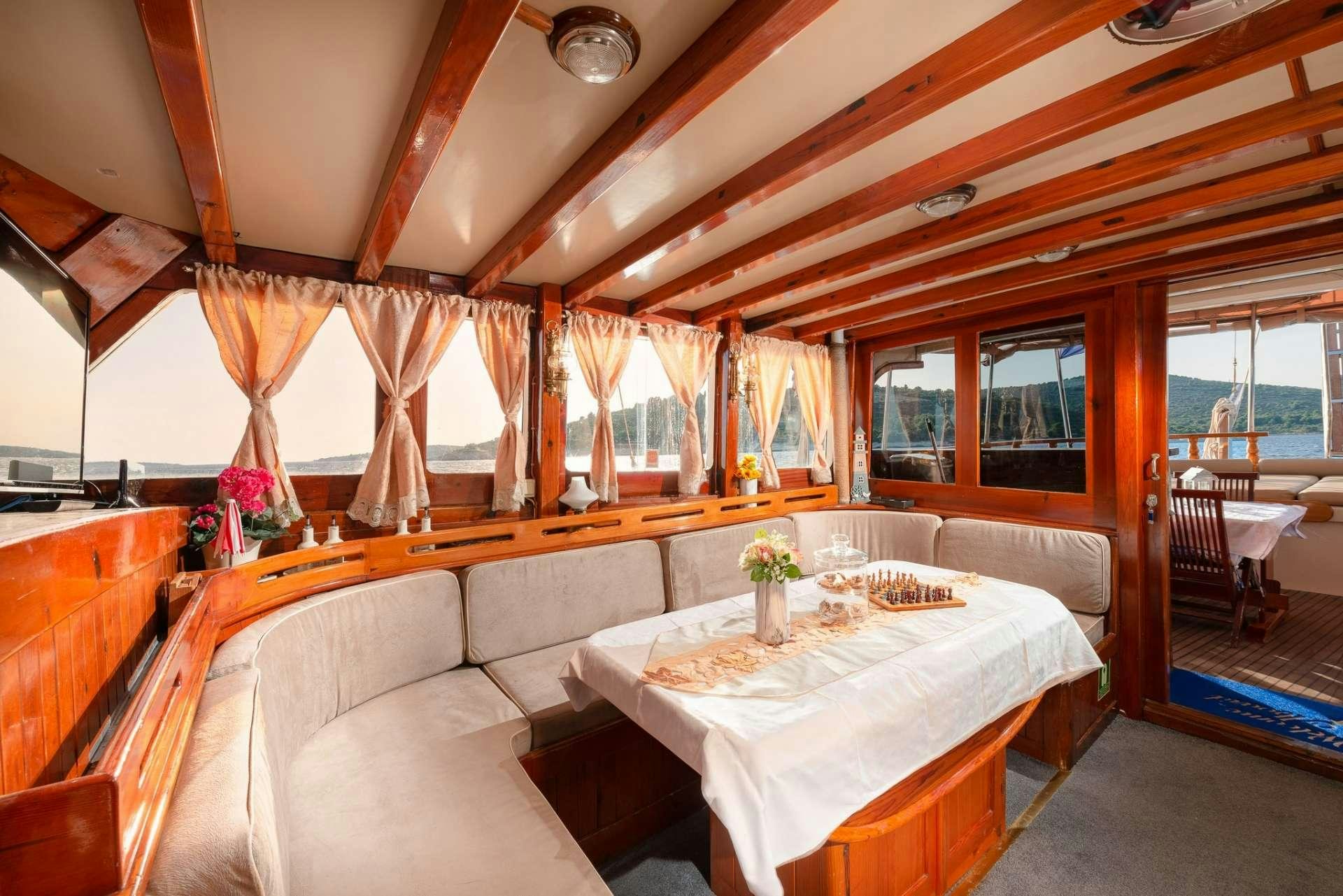 a room with a table and couch aboard Dona Yacht for Charter