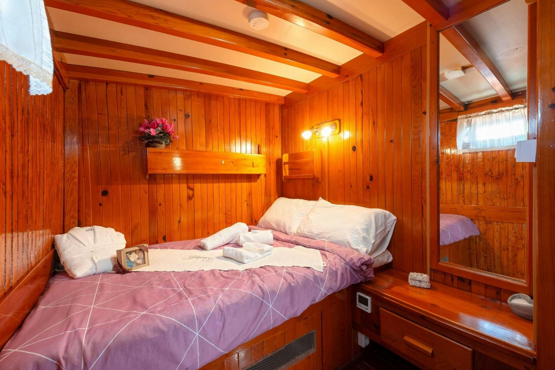 a room with wooden walls and a bed aboard Dona Yacht for Charter