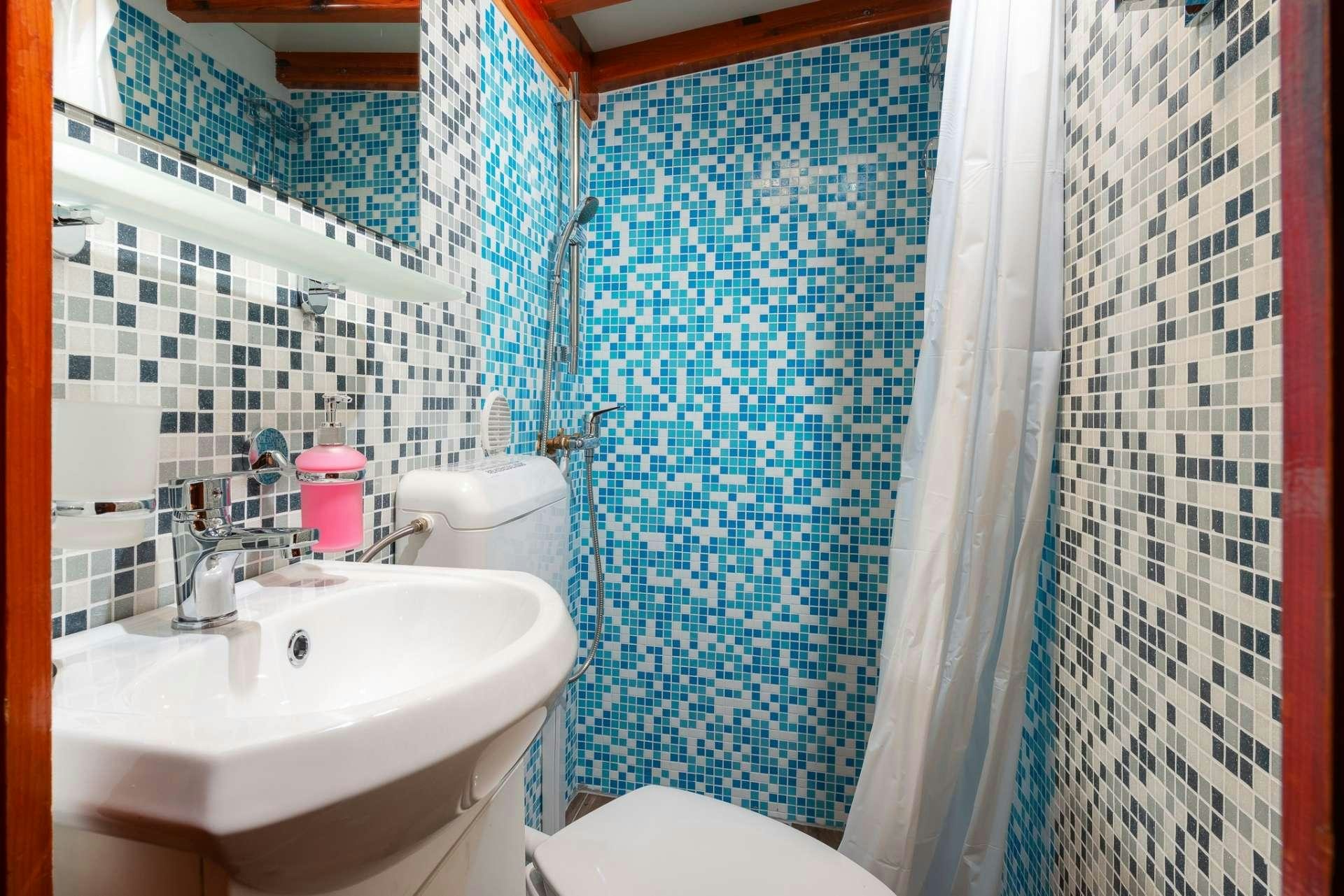 a bathroom with a sink and a shower aboard Dona Yacht for Charter