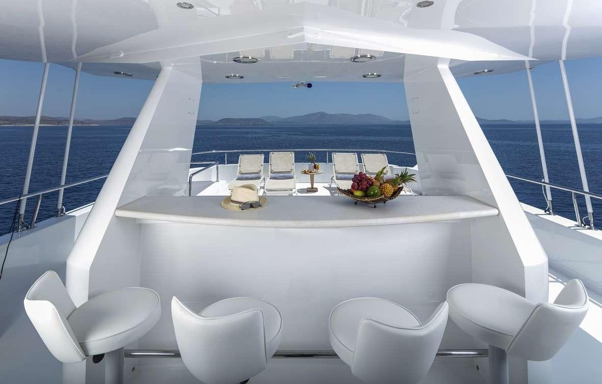 a room with a large window and a table with chairs and a view of the ocean aboard ENDLESS SUMMER Yacht for Charter