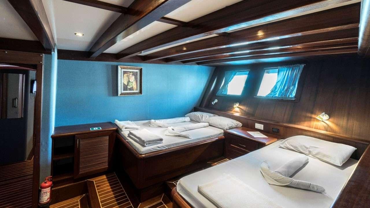 a room with a couple beds aboard LOVE BOAT Yacht for Charter
