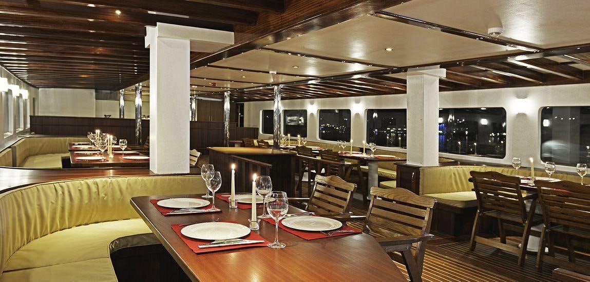 a restaurant with a table and chairs aboard LOVE BOAT Yacht for Charter