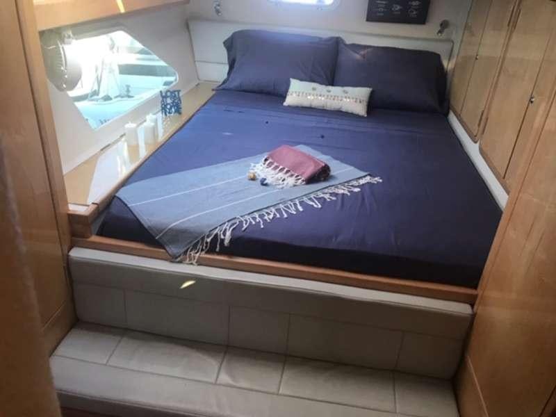 a bed with a blue cover aboard GUINEVERE Yacht for Charter