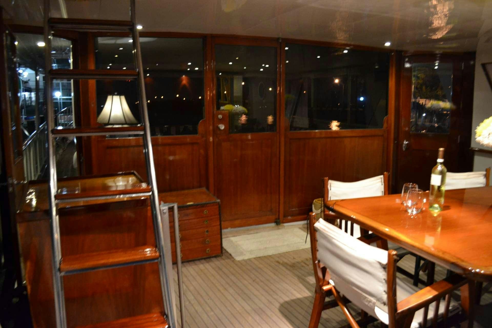 a wooden dining table and chairs aboard BONAPARTE Yacht for Charter