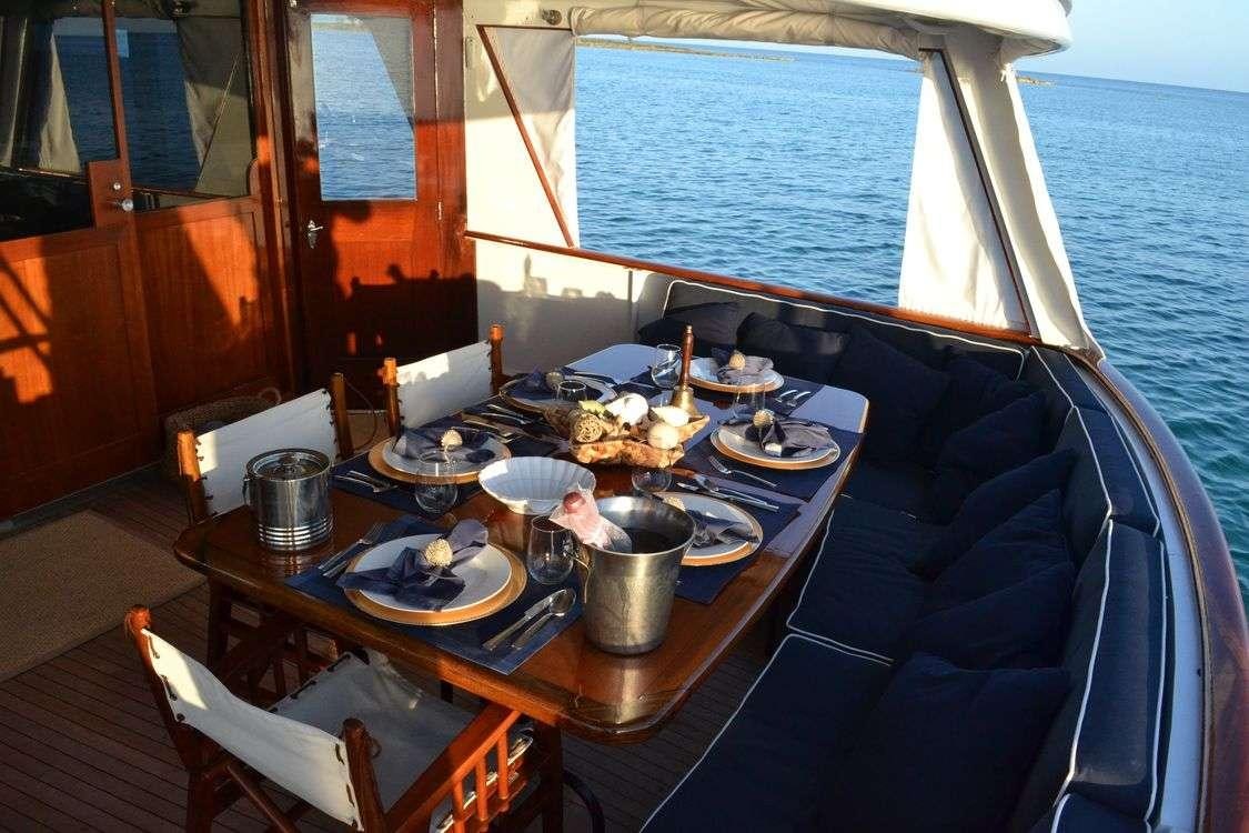 a boat with a table set for a meal aboard BONAPARTE Yacht for Charter