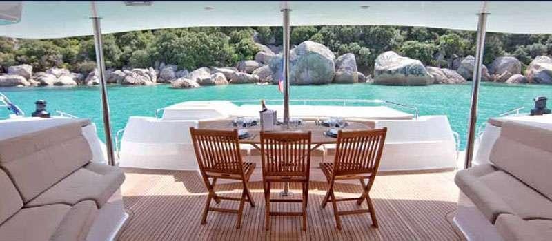 a table and chairs on a deck overlooking a body of water aboard MOBY DICK Yacht for Charter