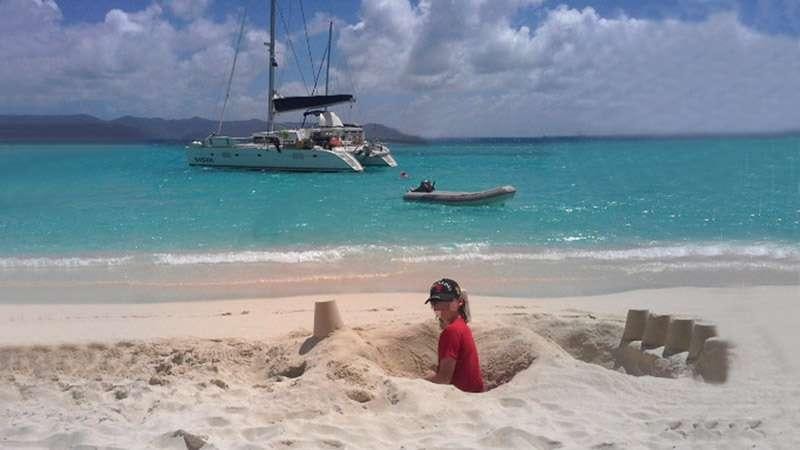 a person sitting on a beach aboard SASHA Yacht for Charter