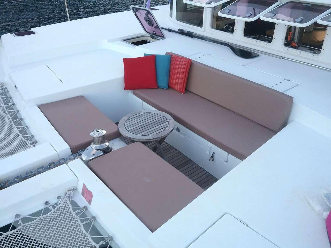 a white couch with a red and blue pillow on it aboard SASHA Yacht for Charter