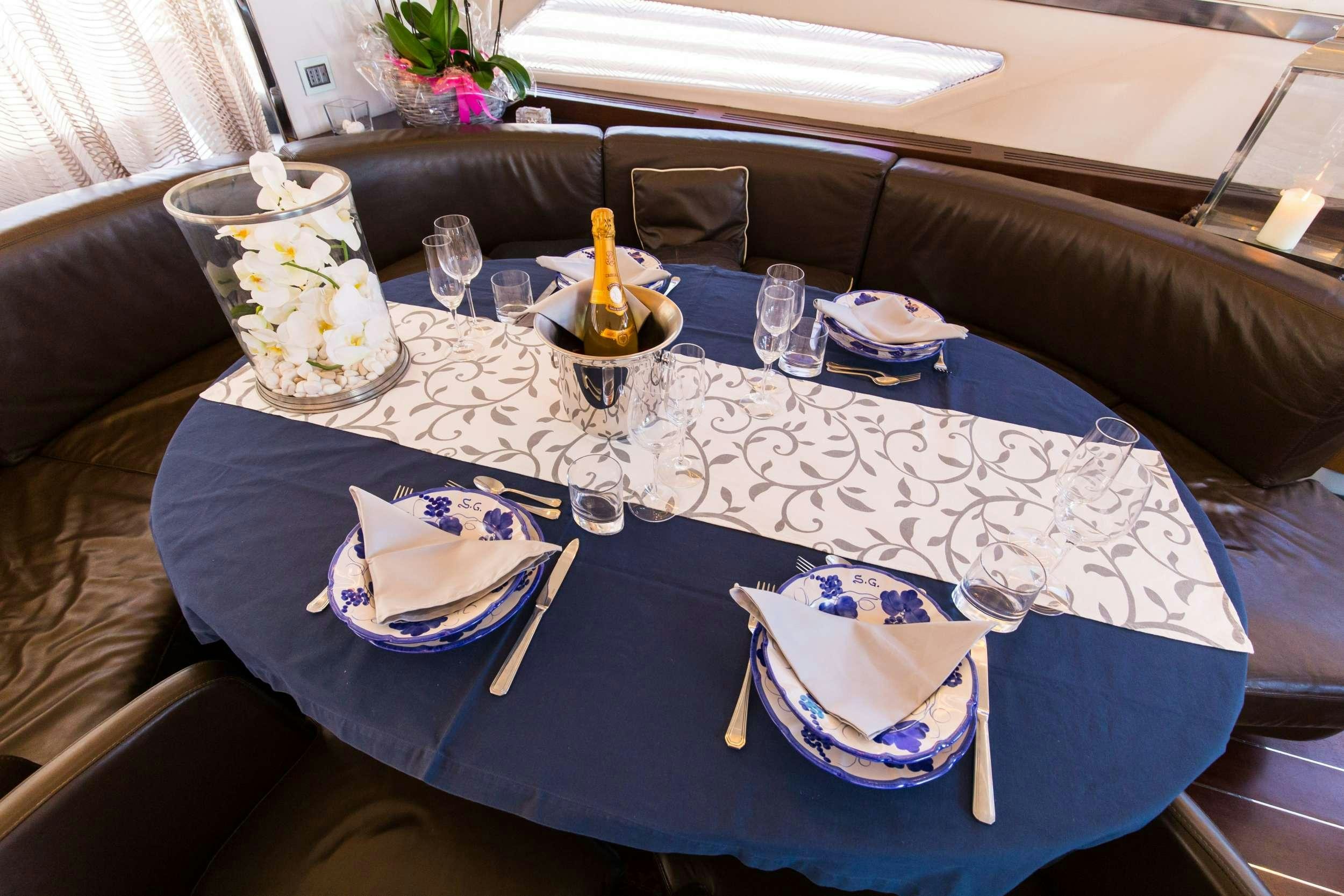 a table with plates and silverware aboard CINQUE Yacht for Charter