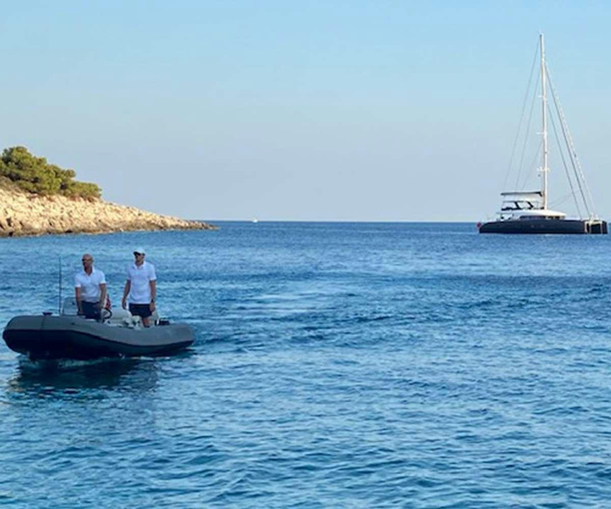 a couple of men on a boat aboard LA GATTA Yacht for Charter