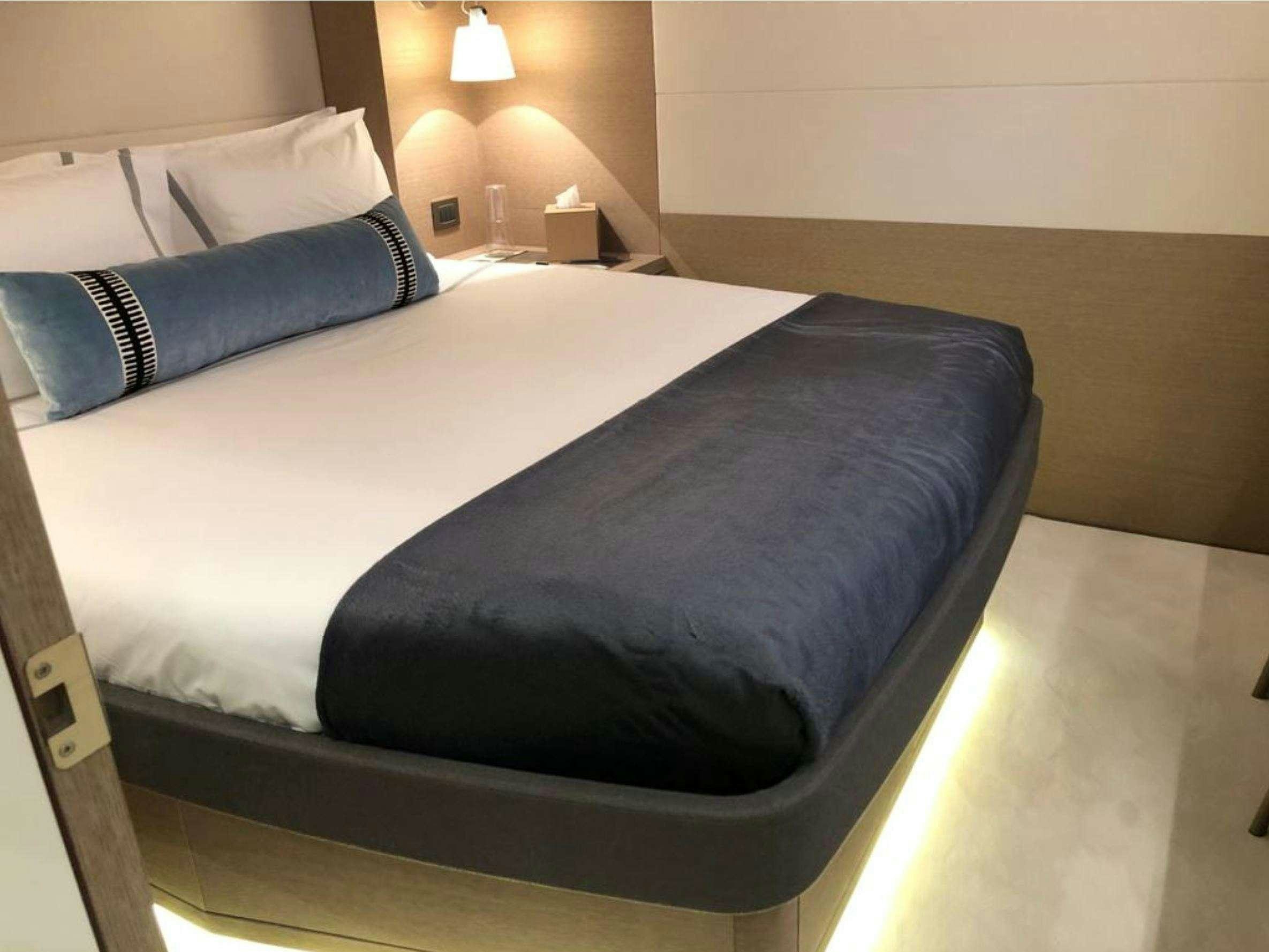 a bed with a black comforter aboard LA GATTA Yacht for Charter