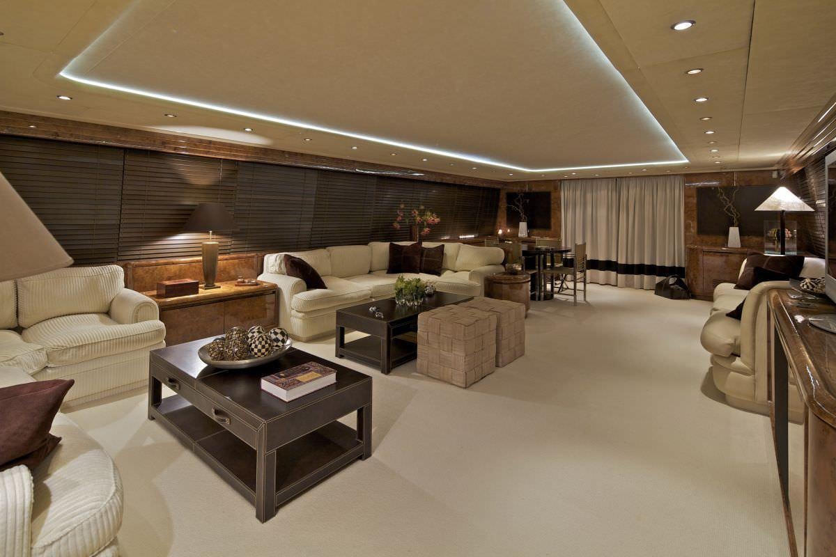 a living room with a large couch and a coffee table aboard OBSESION 120 Yacht for Charter