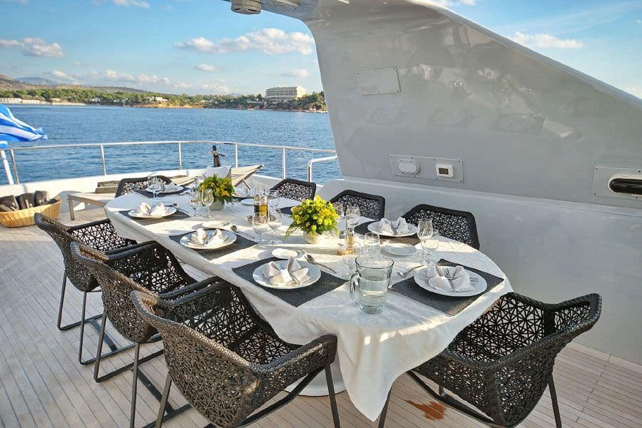 a table set for a meal on a boat aboard OBSESION 120 Yacht for Charter