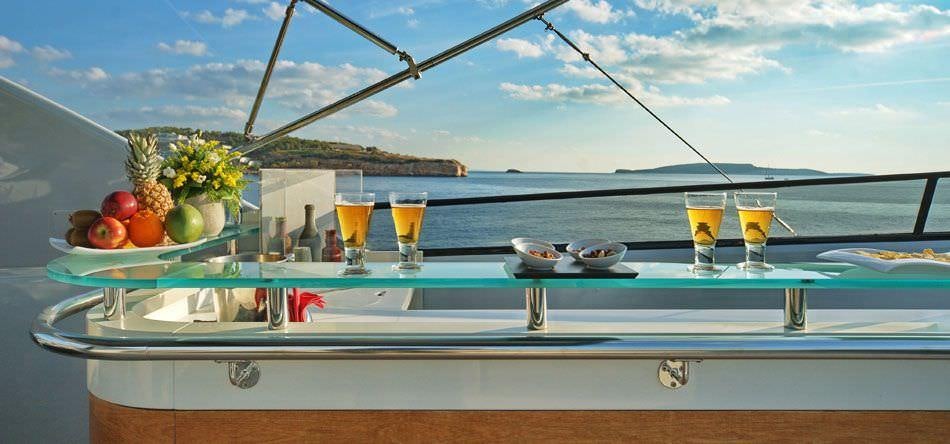 a table with food and drinks on it aboard OBSESION 120 Yacht for Charter