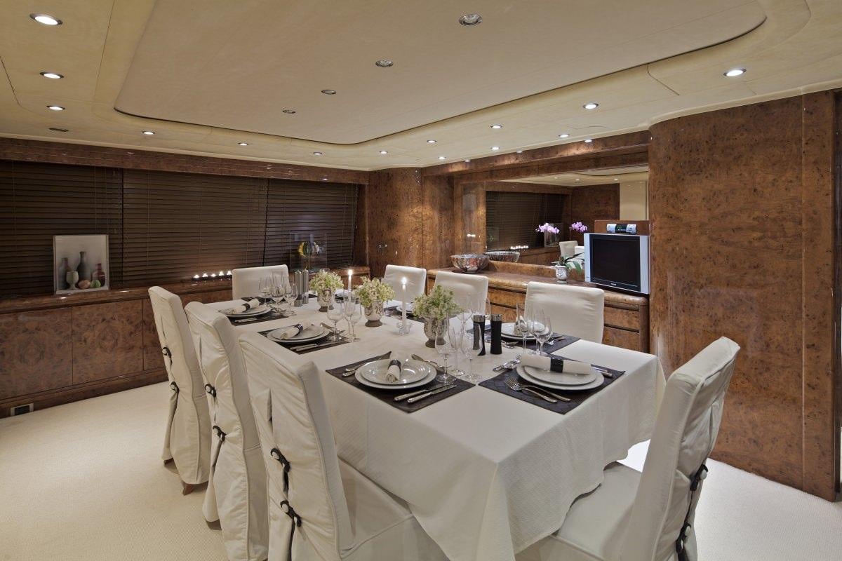 a large room with a table and chairs aboard OBSESION 120 Yacht for Charter