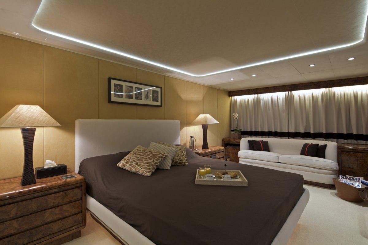 a bedroom with a bed and a couch aboard OBSESION 120 Yacht for Charter