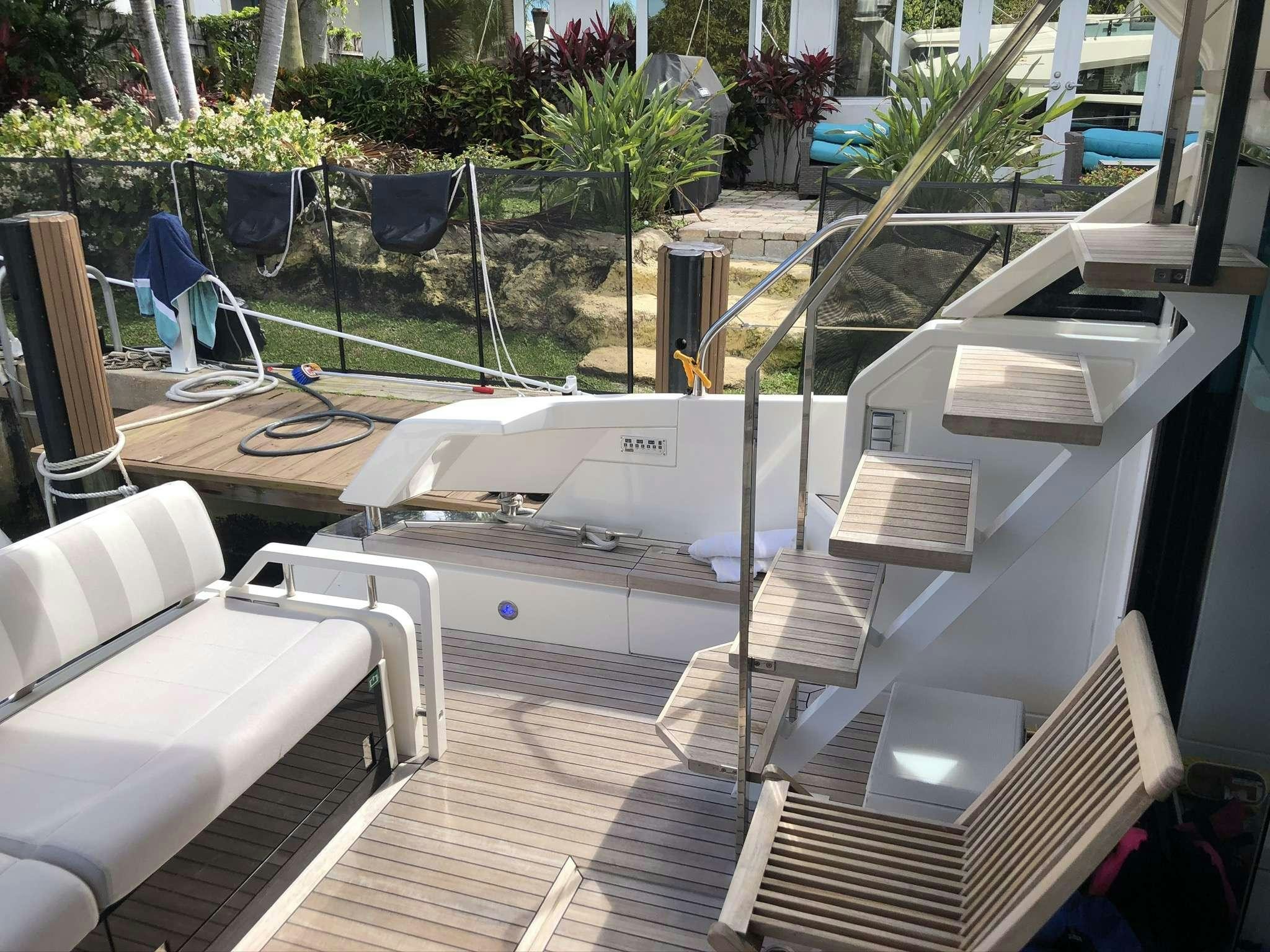 a deck with a deck and chairs aboard Synergy Yacht for Charter