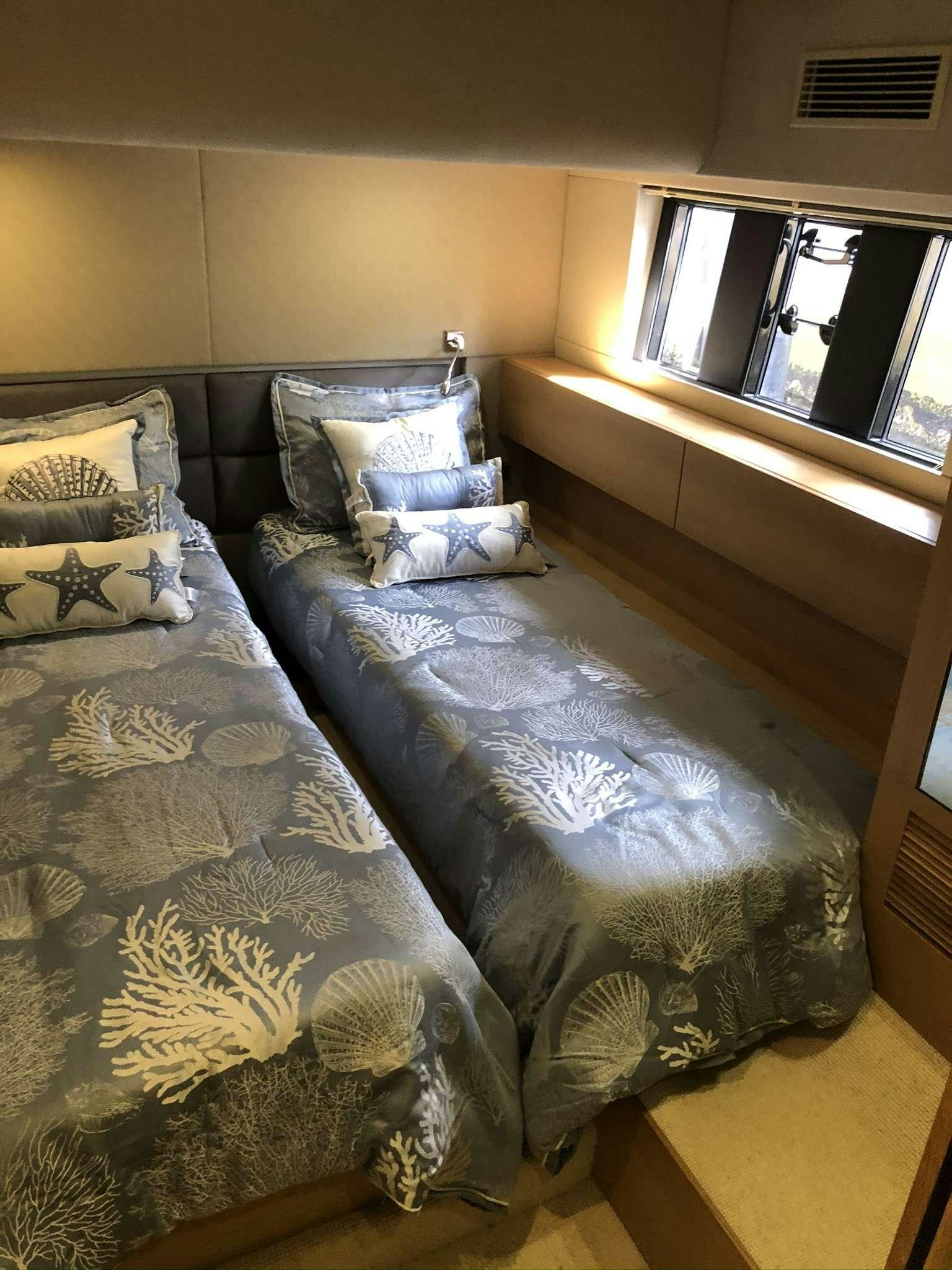 a bed with a blue comforter aboard Synergy Yacht for Charter