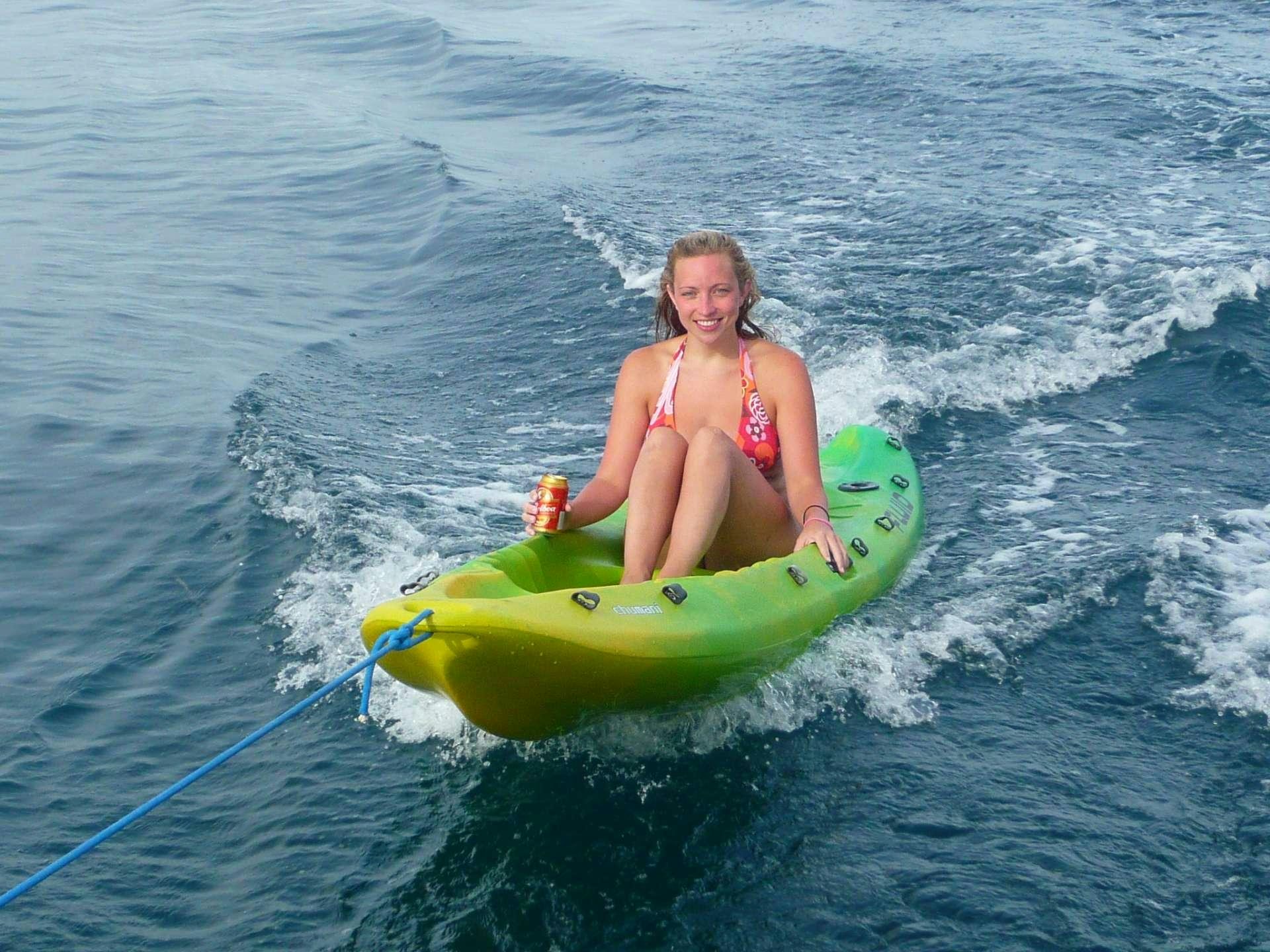 a girl in a bikini on a green floaty in the water aboard EXTASEA 2 Yacht for Charter