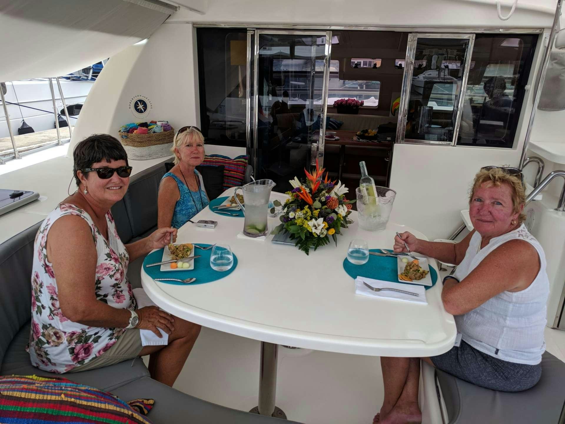 a group of people sitting at a table eating aboard EXTASEA 2 Yacht for Charter