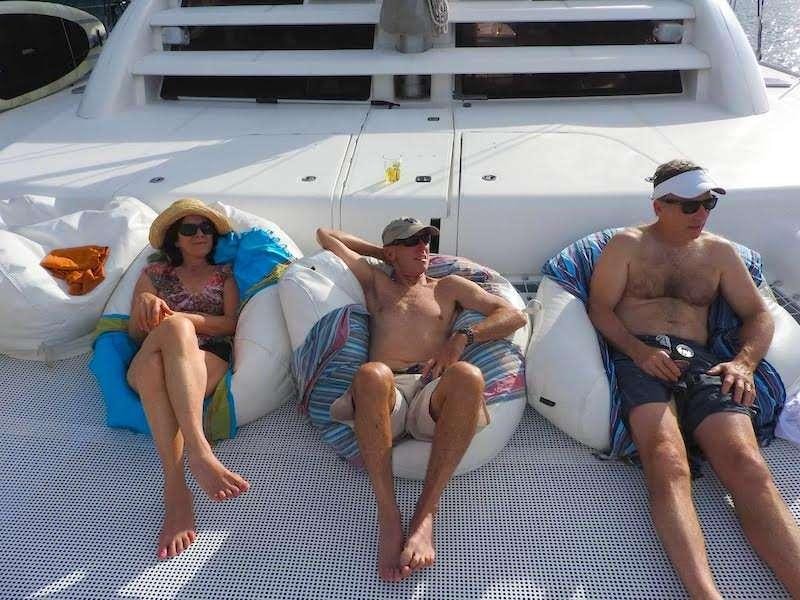 a group of people sitting on a beach aboard EXTASEA 2 Yacht for Charter