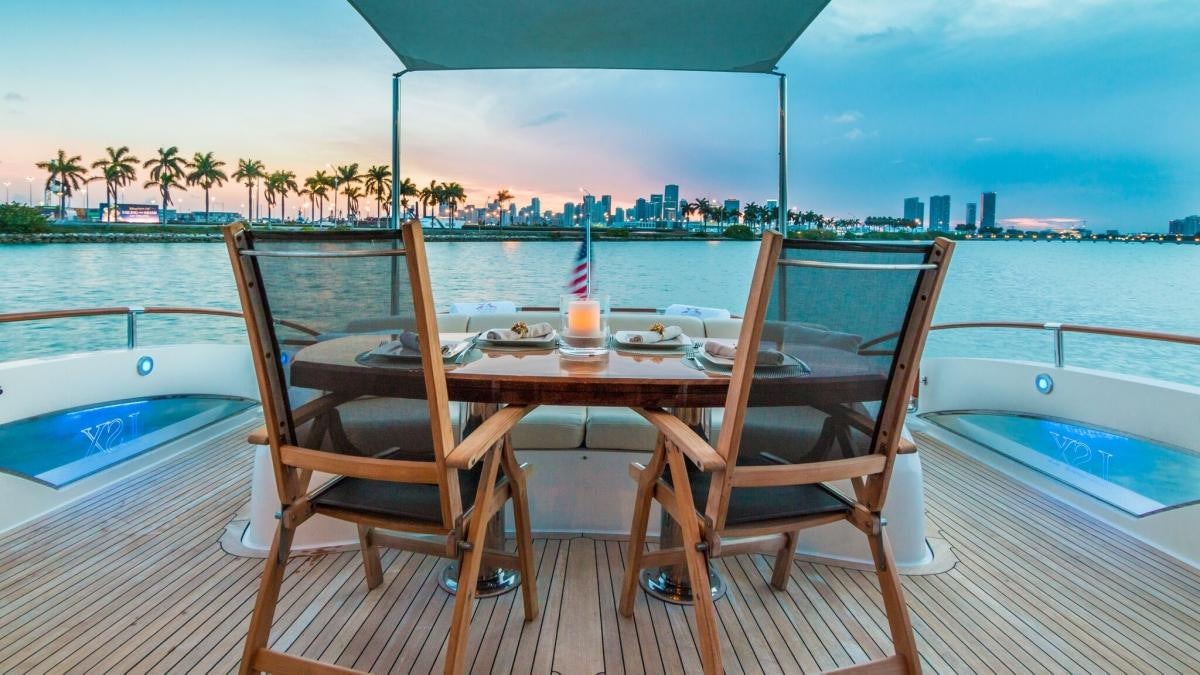 a table and chairs on a deck overlooking a city aboard CARPE DIEM Yacht for Charter