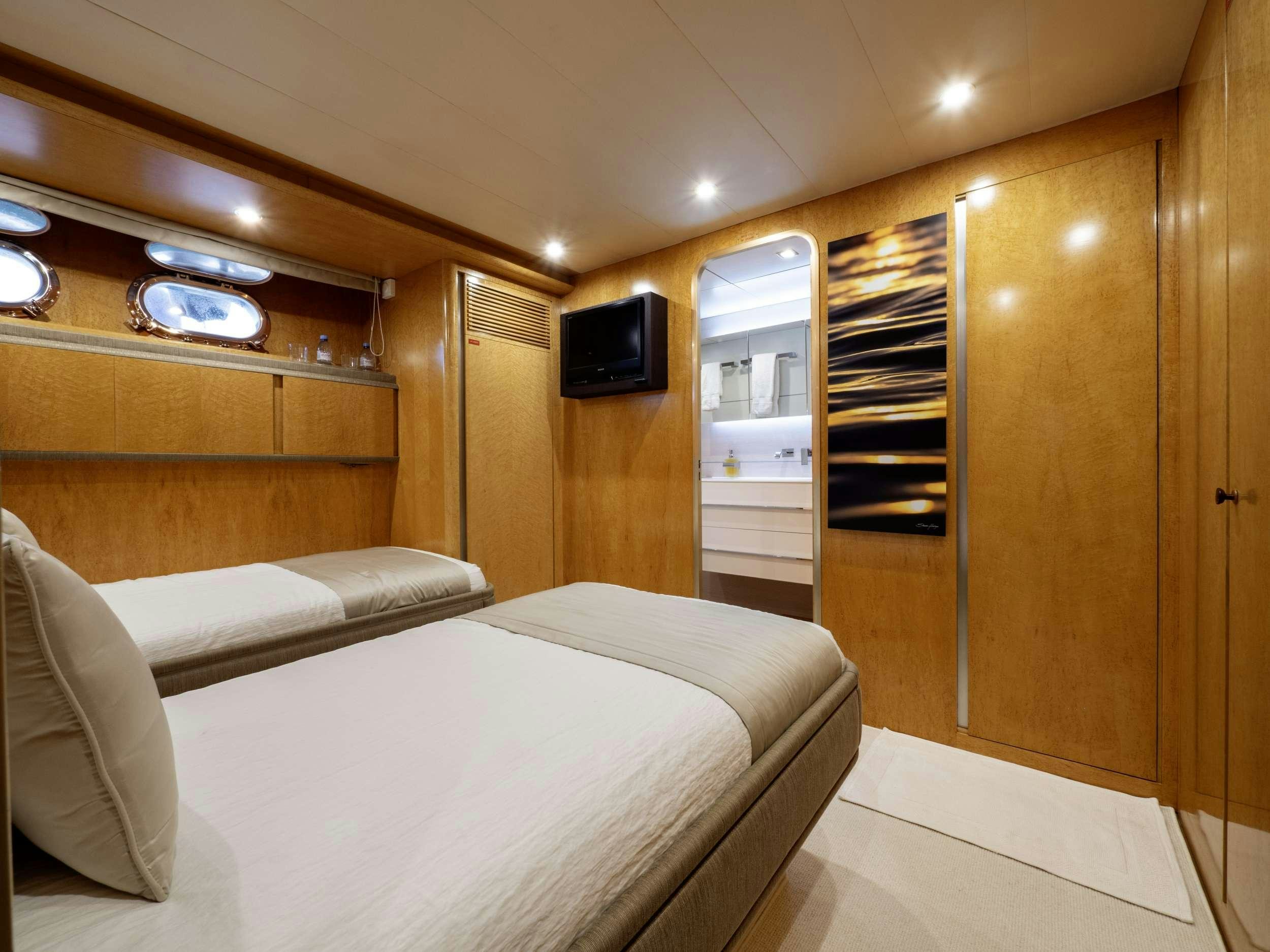 a room with a bed and a television aboard SUNLINER X Yacht for Charter