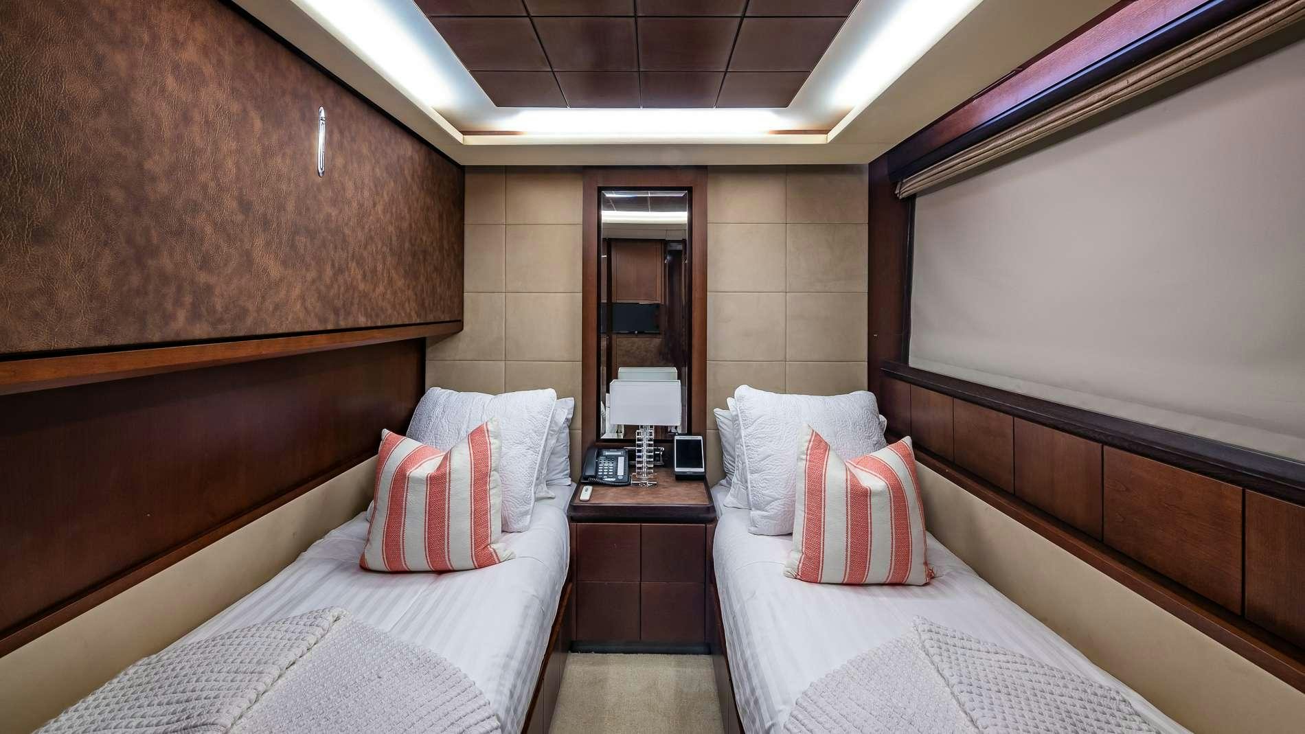 a room with beds and a mirror aboard TAIL LIGHTS Yacht for Charter
