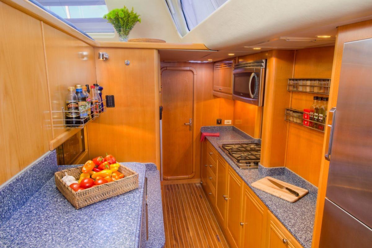 a kitchen with wooden cabinets aboard THE BIG DOG Yacht for Charter