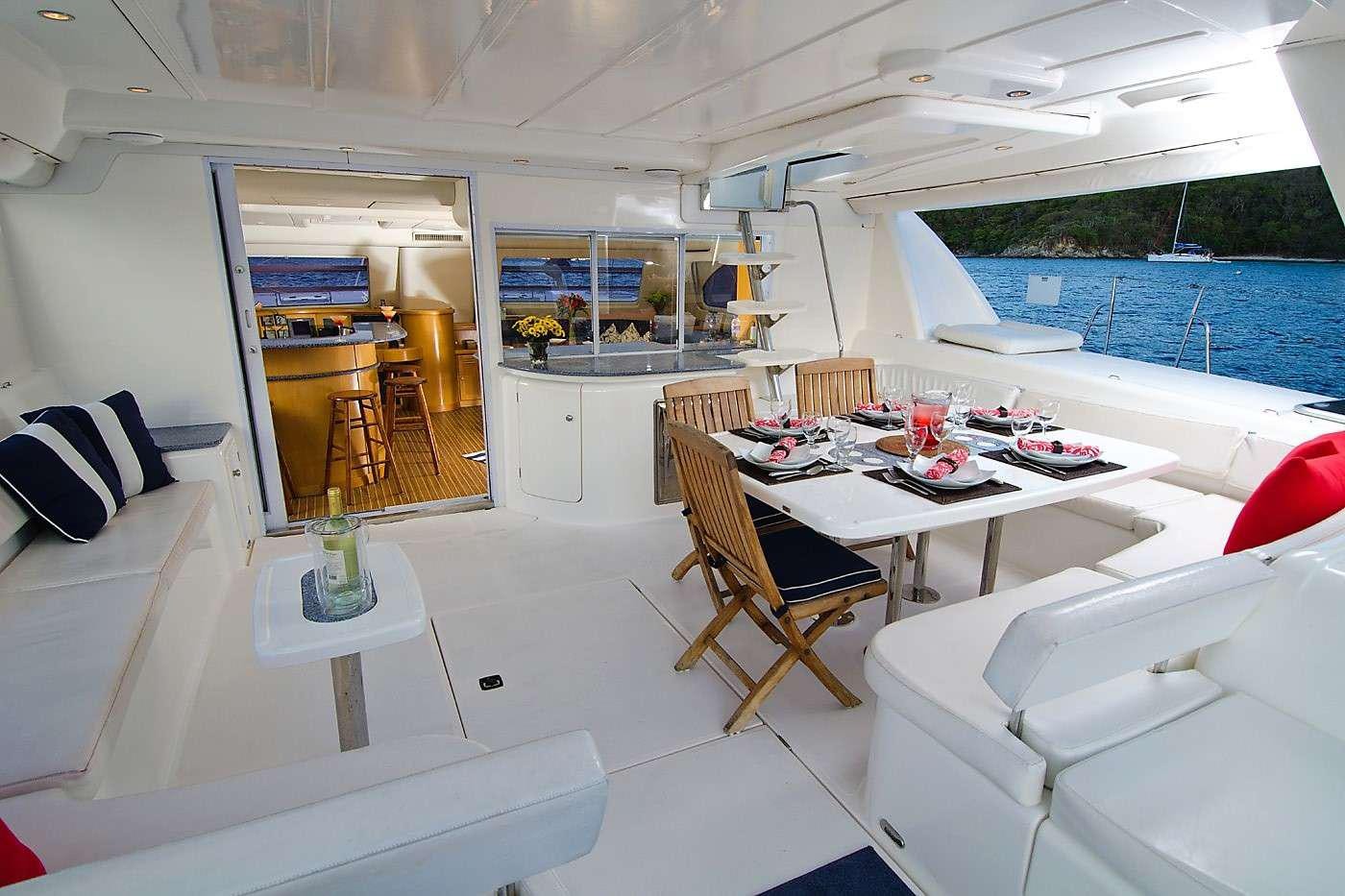 a room with a table chairs and a pool aboard THE BIG DOG Yacht for Charter