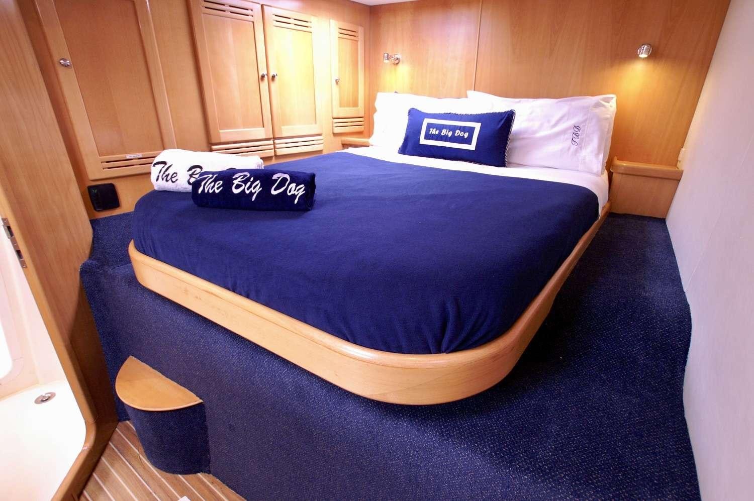 a bed with a blue sheet aboard THE BIG DOG Yacht for Charter