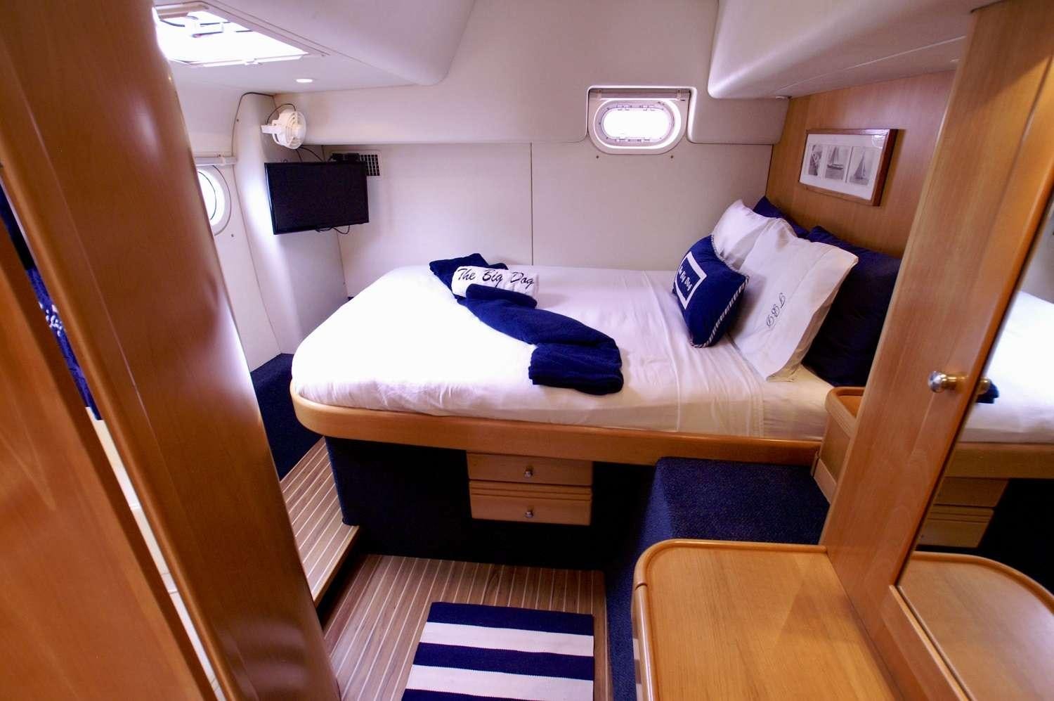 a room with a bed and a television aboard THE BIG DOG Yacht for Charter