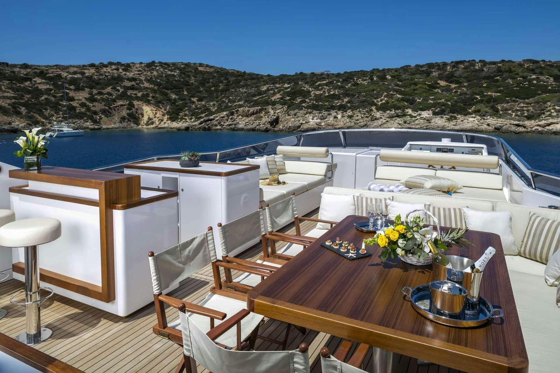 a table with chairs and a pool aboard ALEXIA AV Yacht for Charter