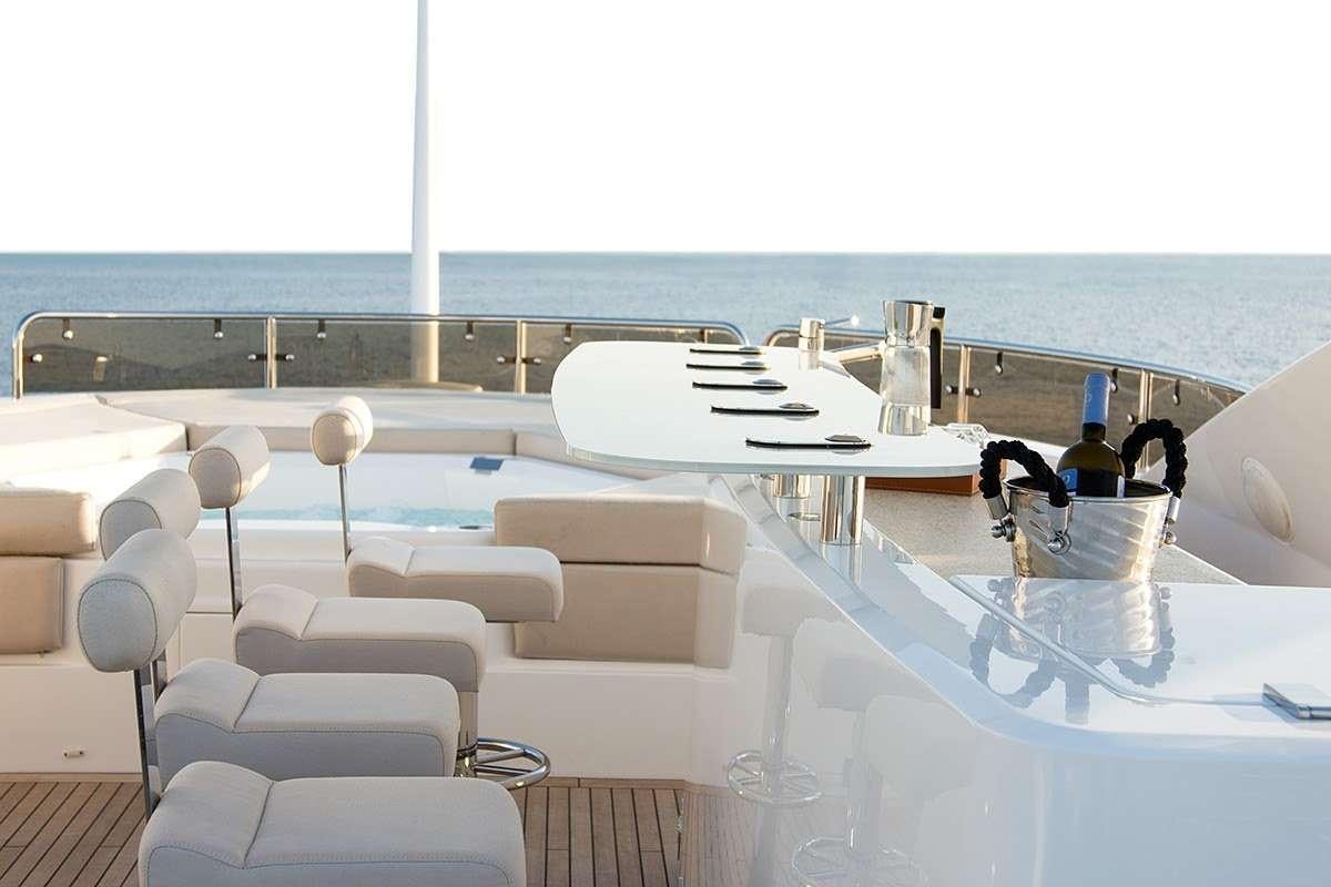 a table with chairs and a glass on it aboard PATHOS Yacht for Charter