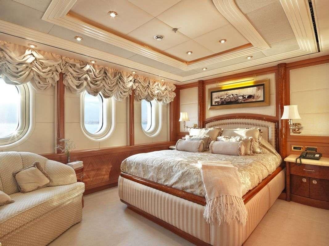 a bedroom with a bed and a chair aboard CAPRI I Yacht for Charter