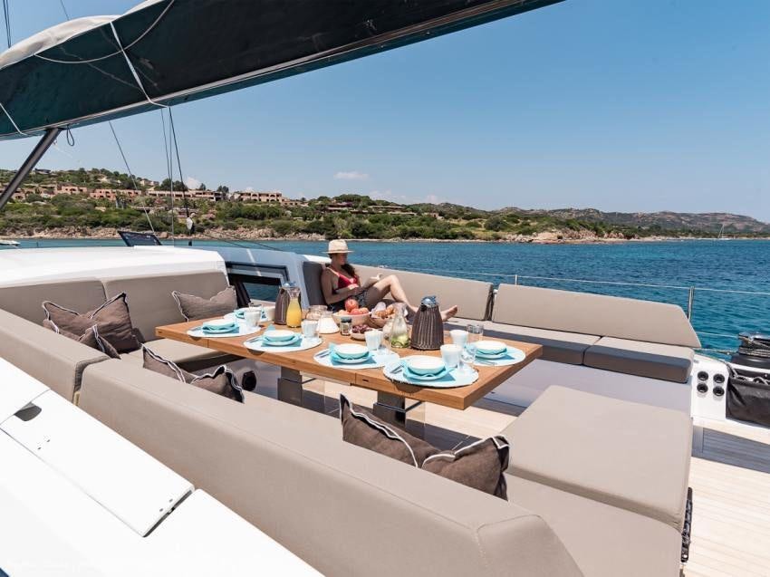a person sitting at a table on a boat aboard NEYINA Yacht for Charter