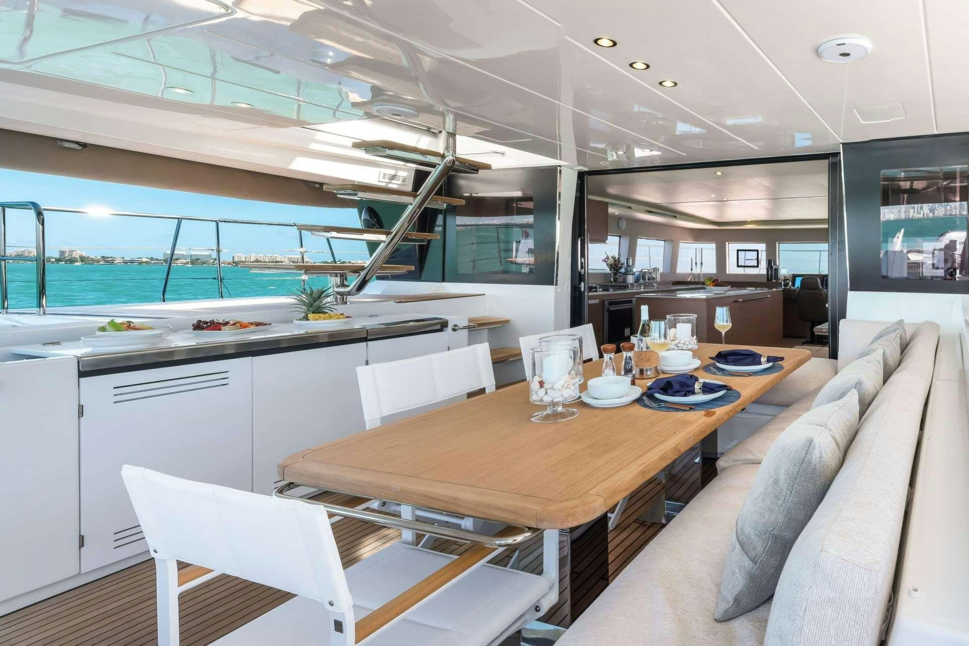 a modern looking kitchen with a large table and chairs aboard LONG MONDAY Yacht for Charter