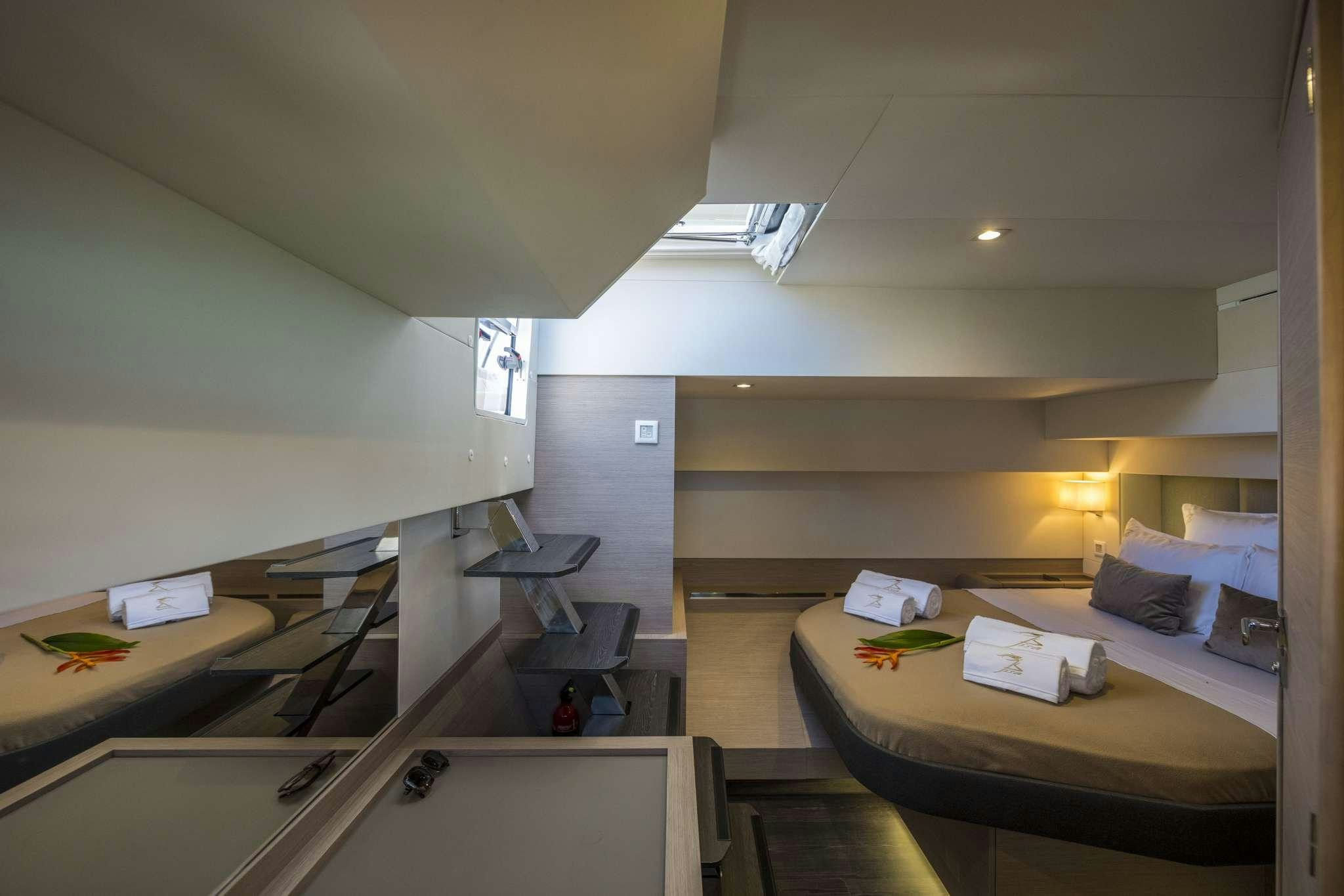 a room with a bed and desk aboard LISA OF THE SEAS Yacht for Charter