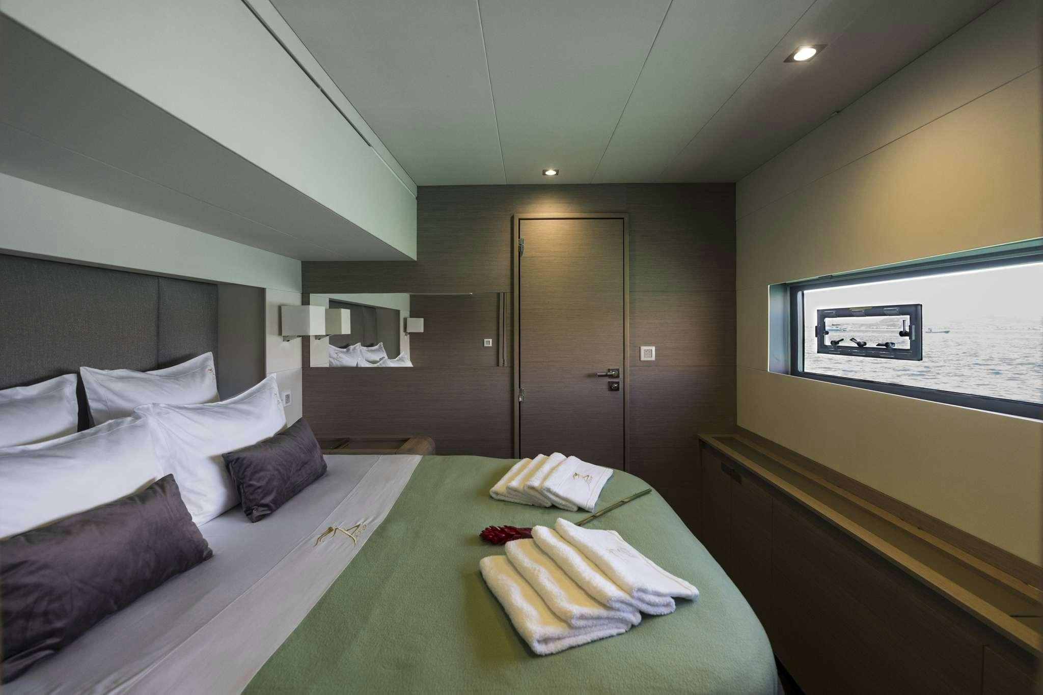 a hotel room with a bed and a table aboard LISA OF THE SEAS Yacht for Charter