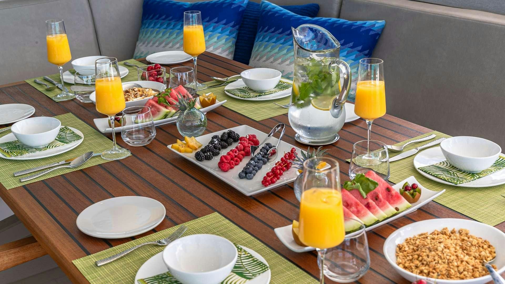 a table with food and drinks on it aboard SUR L'EAU Yacht for Charter