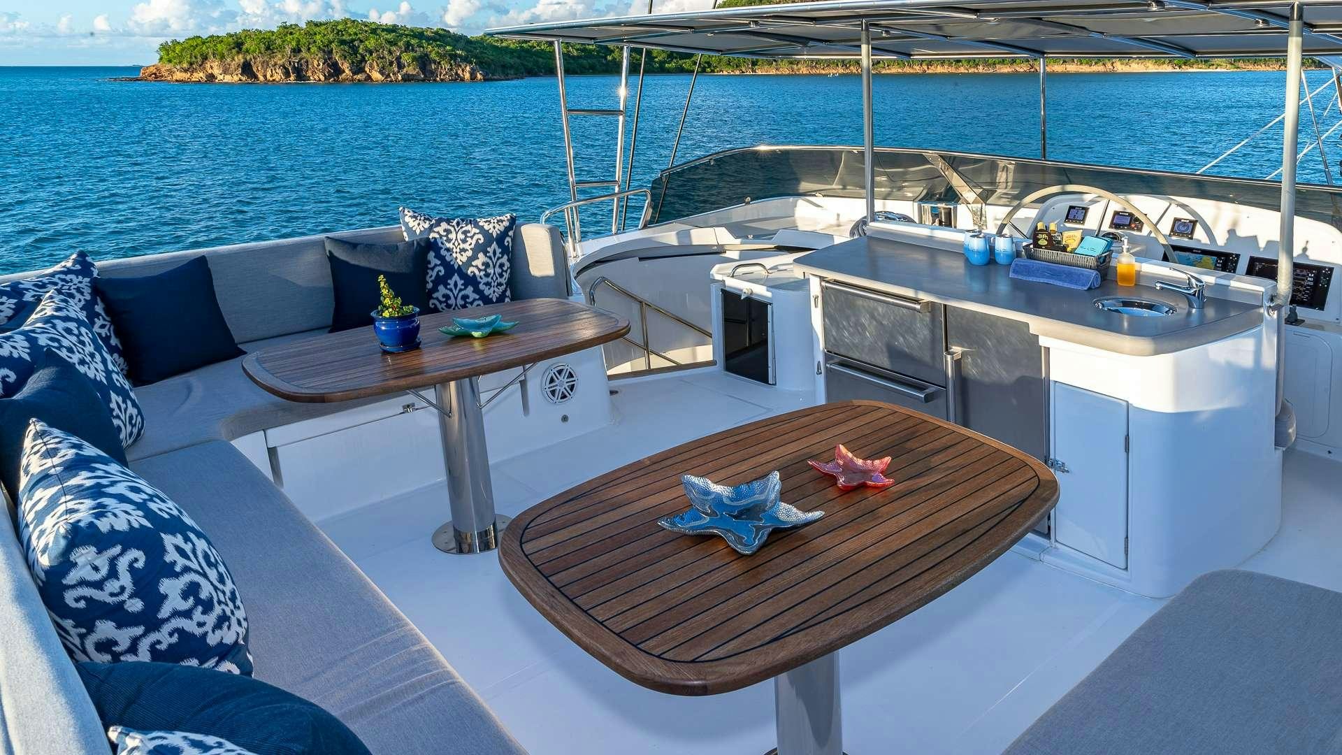a deck with a table and chairs on it aboard SUR L'EAU Yacht for Charter