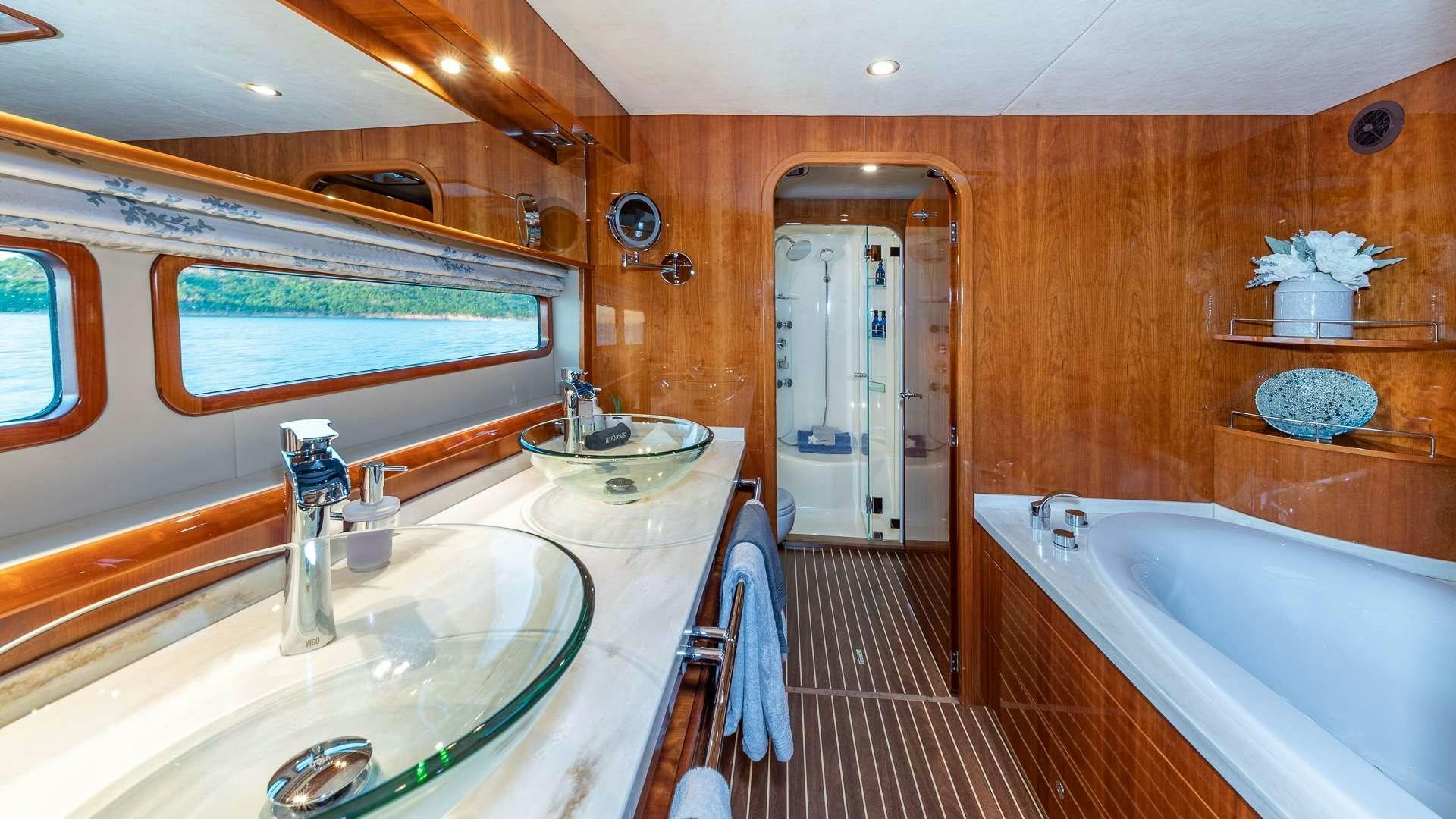 a bathroom with a tub sink and a sink aboard SUR L'EAU Yacht for Charter