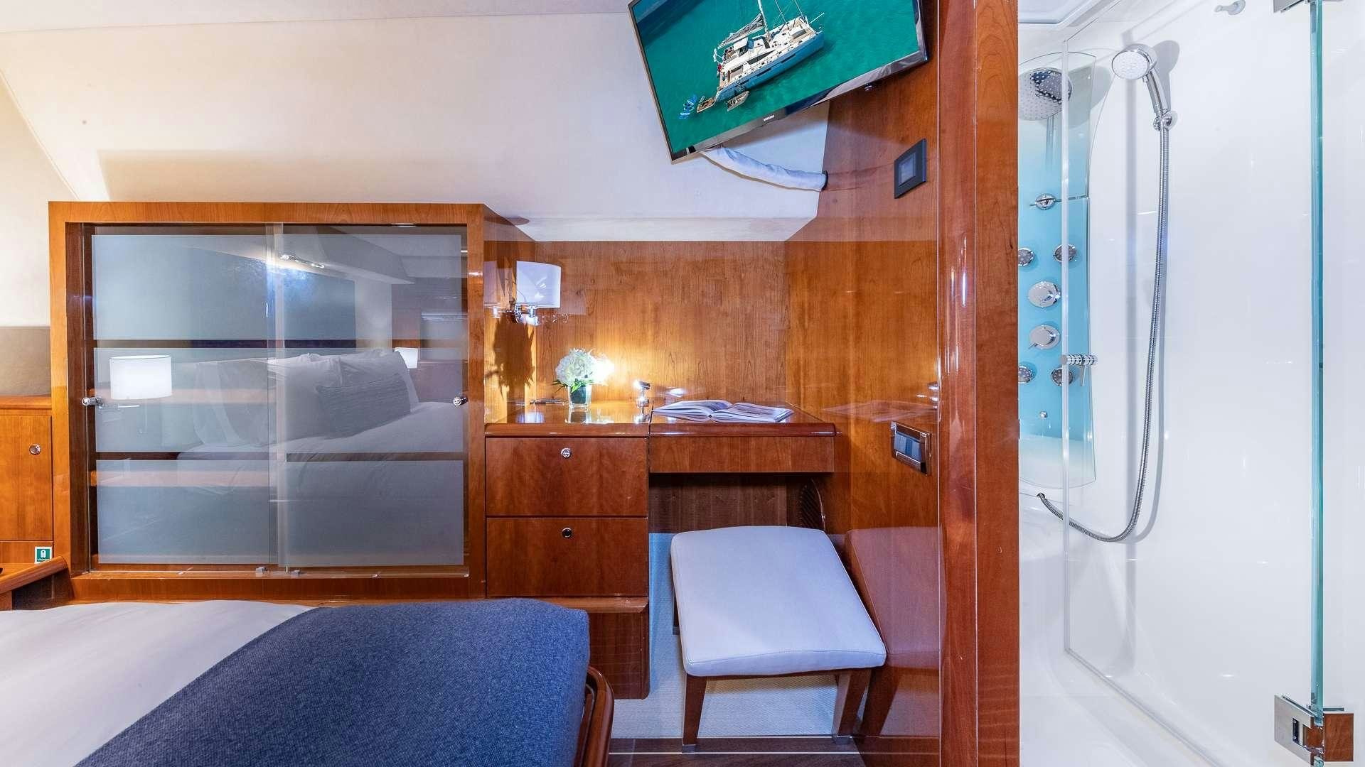 a room with a bed and a desk aboard SUR L'EAU Yacht for Charter