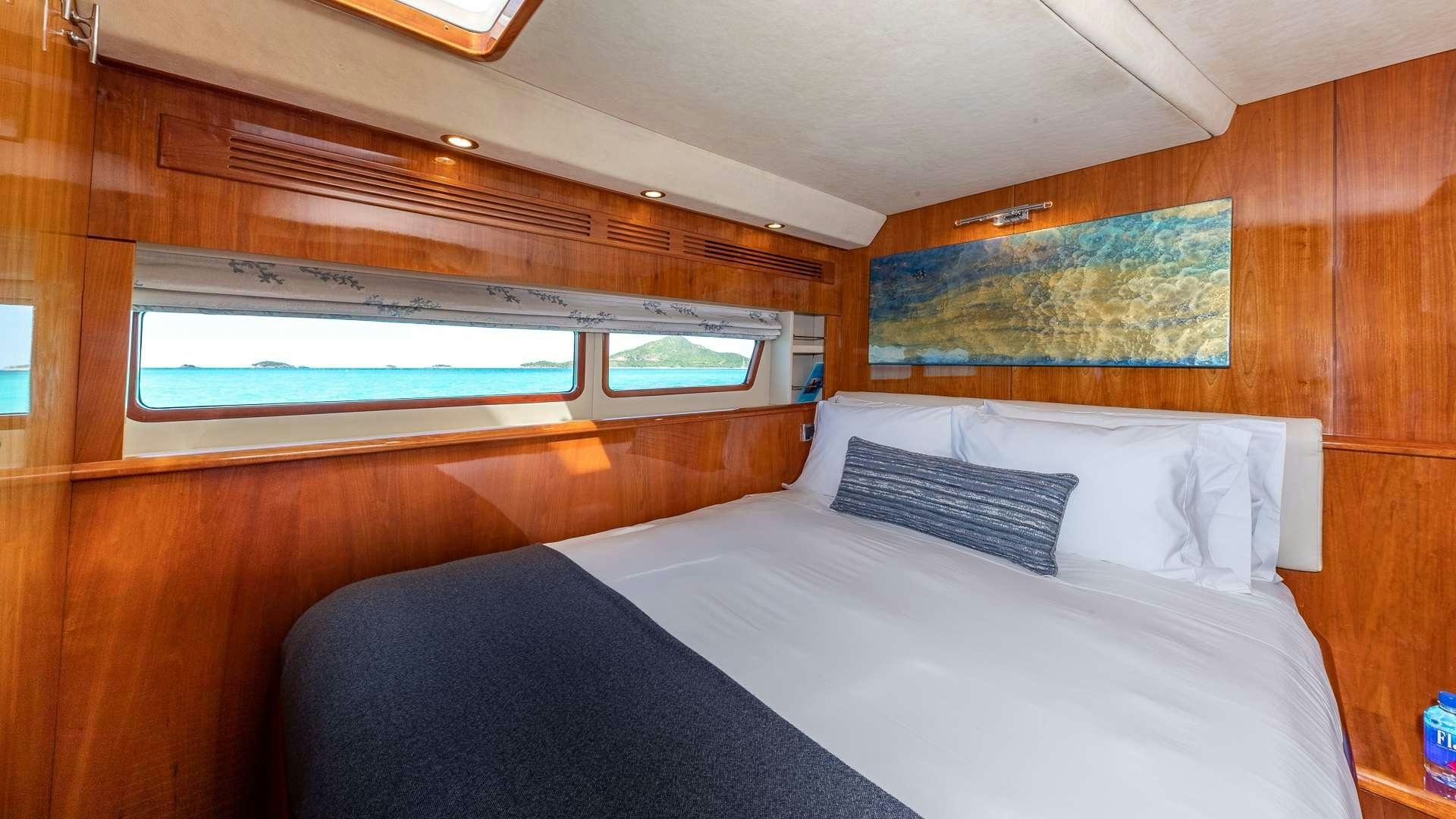 a room with a bed and a window aboard SUR L'EAU Yacht for Charter