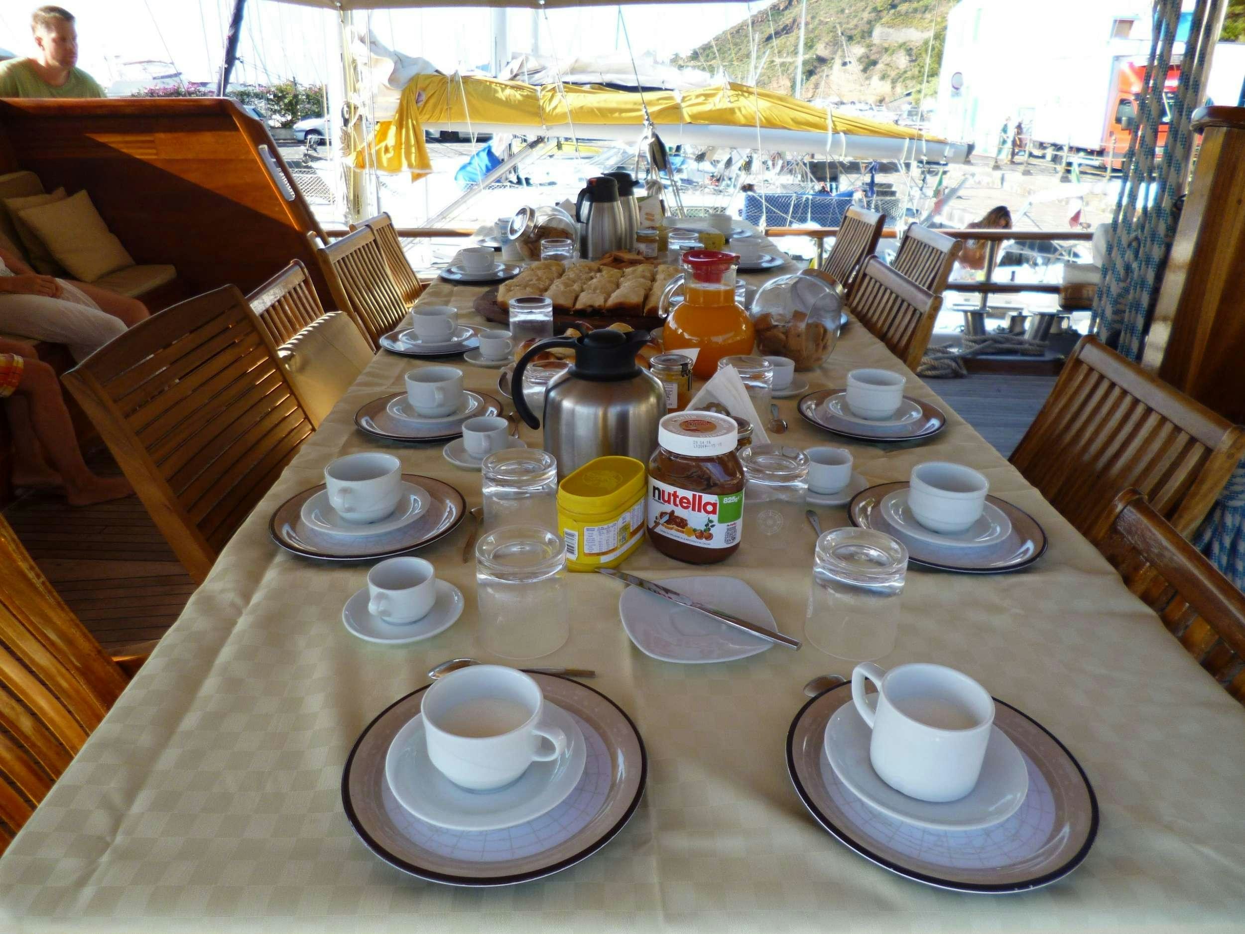 a table with plates and cups on it aboard Donna Marisa Yacht for Charter